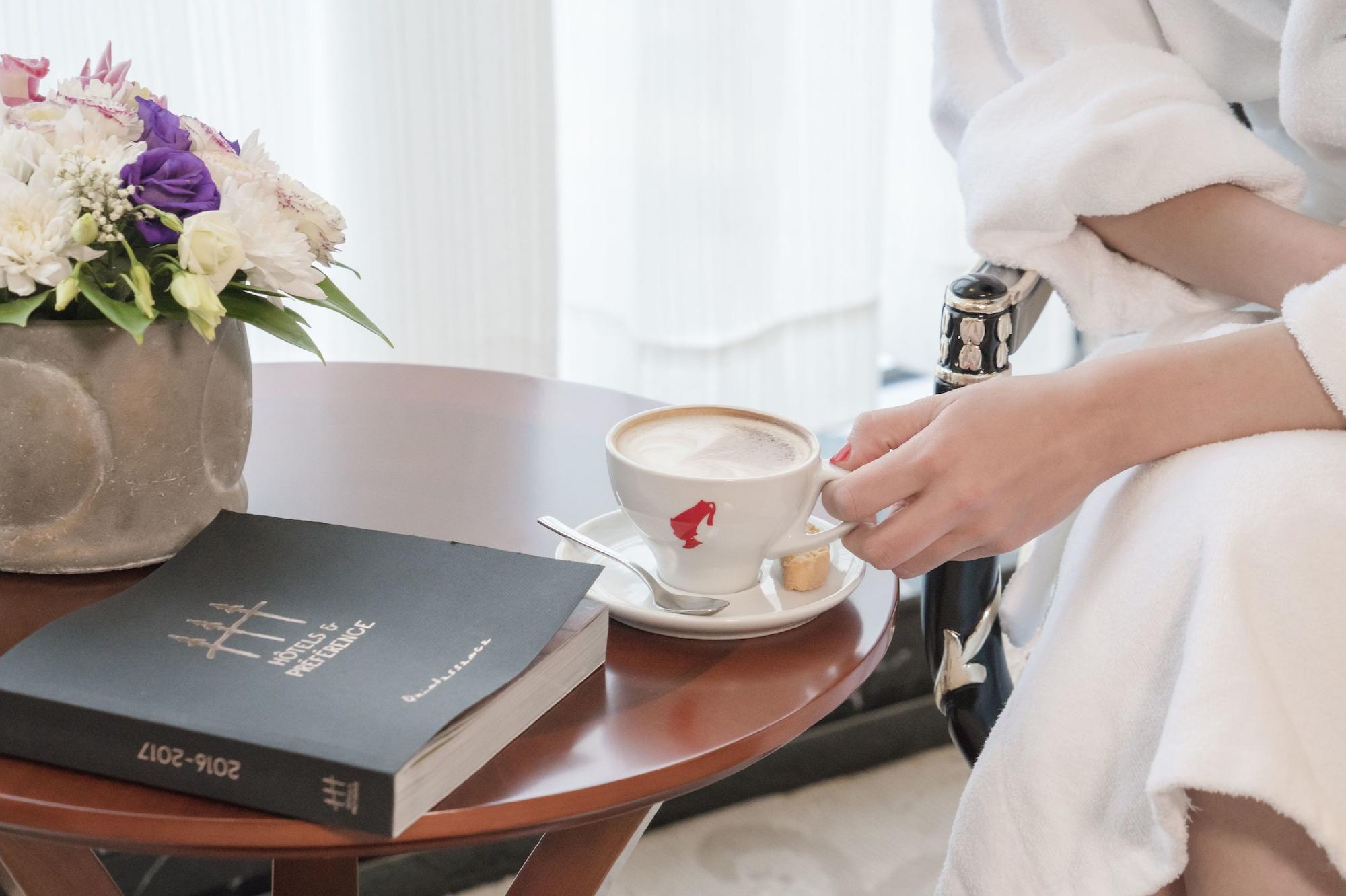 华凌第比利斯酒店 外观 照片 A woman holding a cup of coffee